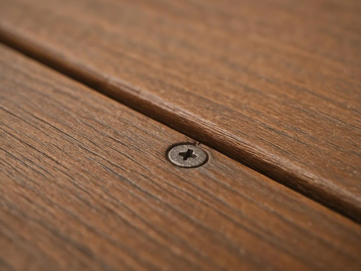Close-up of a wooden deck board with a single screw in the center